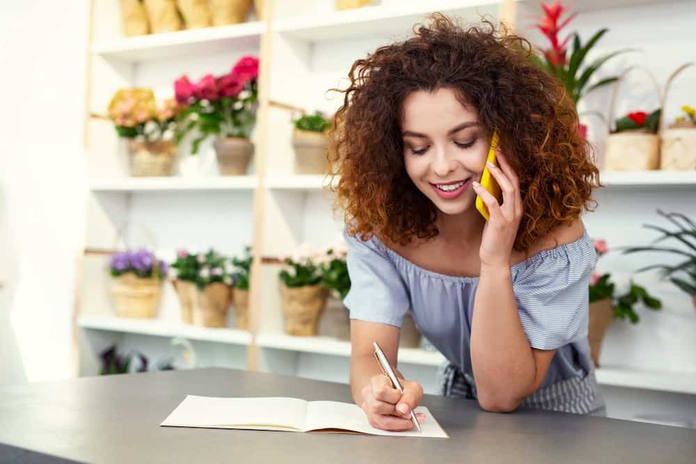 Women florist taking a wholesale order over the phone