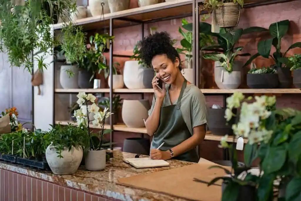 Female botanic owner on phone with vendor