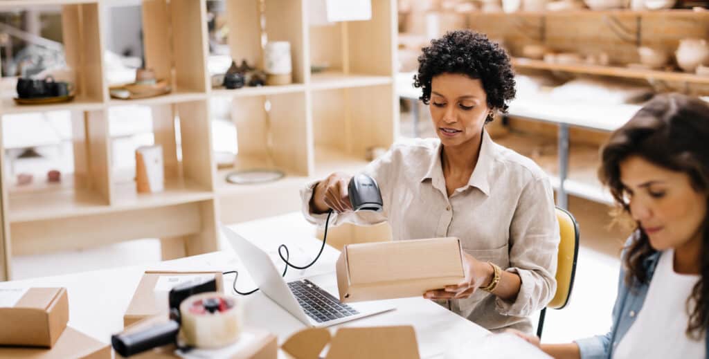 Online store owner scanning the barcode of a package box in a warehouse.