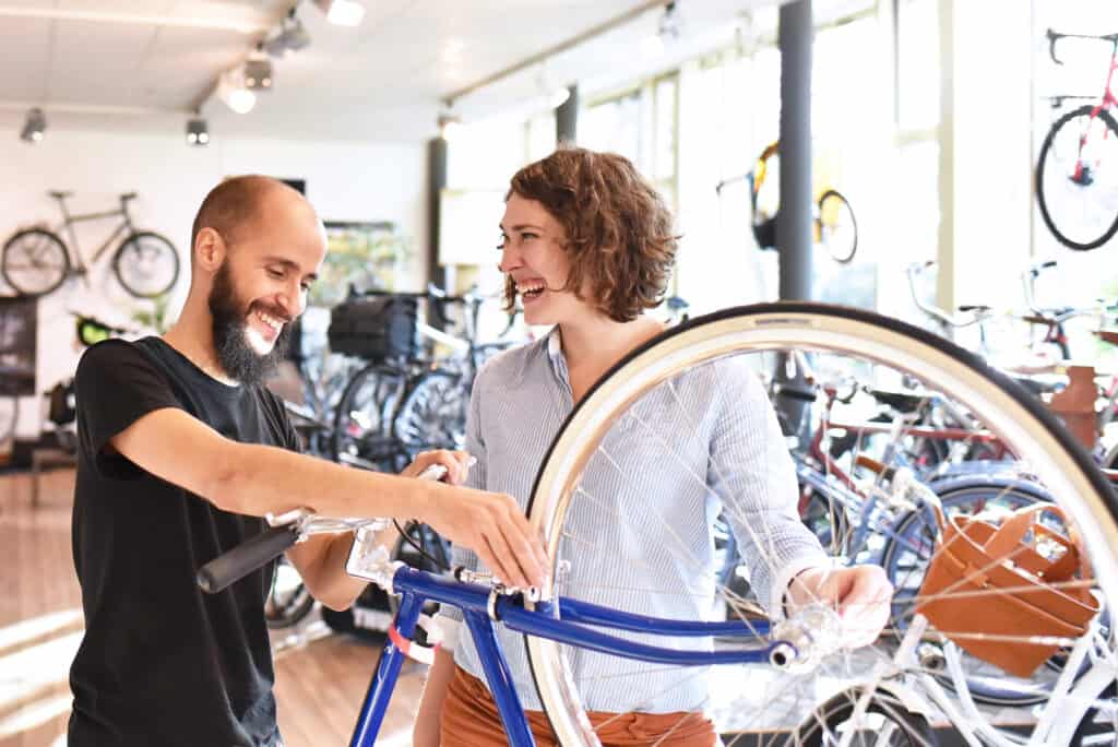 Bicycle shop owner showing customer a new bike model